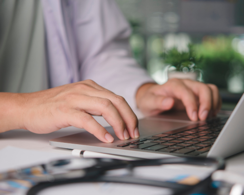 Peptides for physicians — clinician typing on a laptop while reviewing supply records
