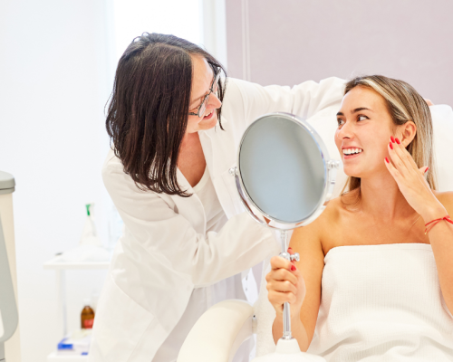 Client holding a mirror after an aesthetic treatment with a practitioner