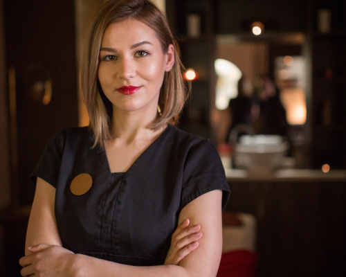 Med spa owner standing with arms crossed in a dimly lit clinic