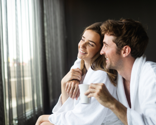 Two spa guests in white robes relaxing in a treatment lounge